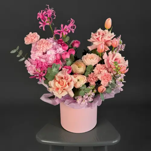 Цветочная композиция из роз, ранункулуса и нерине в шляпной коробке